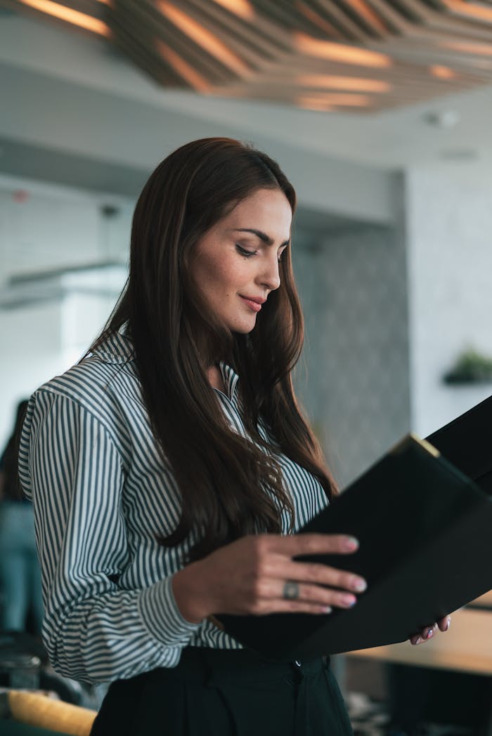 home-img Businesswoman reading documents in a modern office setting.